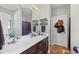 Bright bathroom featuring a double sink vanity with dark wood cabinets, decorative shelves and a large mirror at 715 Hobonny Loop, Longs, SC 29568