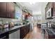 Bright kitchen showcasing dark wood cabinets, stainless steel appliances, granite countertops, and a view into the dining area at 715 Hobonny Loop, Longs, SC 29568