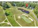 Overhead view of a golf course with sand traps, a pond with a fountain, and luxury homes in the neighborhood at 765 Shaftesbury Ln., Conway, SC 29526