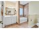 A bright bathroom featuring a soaking tub with tiled walls and a double sink at 765 Shaftesbury Ln., Conway, SC 29526