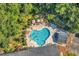 Aerial shot of a community pool with lounge chairs and umbrellas surrounded by mature trees at 765 Shaftesbury Ln., Conway, SC 29526