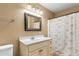 Well-lit bathroom with a vanity, mirror, and shower/tub combo with a decorative curtain at 943 Oak St., Aynor, SC 29511