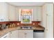 Bright kitchen with white cabinets, stainless sink, and a large window offering a view of the backyard at 943 Oak St., Aynor, SC 29511