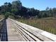 View of the community's wooden boardwalk, extending through a lush marsh environment at Lot 142 Millbank Rd., Georgetown, SC 29440