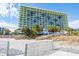 Exterior shot of a high-rise condo with beach access and lush tropical surroundings at 1105 S Ocean Blvd. # 128, Myrtle Beach, SC 29577