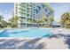 Large outdoor swimming pool with surrounding lounge chairs and a view of the condo tower at 1105 S Ocean Blvd. # 128, Myrtle Beach, SC 29577