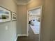 Hallway leading to a bedroom with hardwood floors, neutral walls, and stylish wall decor at 121 Eagle Claw Dr., Carolina Shores, SC 28467