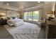 Serene primary bedroom with a decorative accent wall, elegant lighting, and large windows at 121 Eagle Claw Dr., Carolina Shores, SC 28467