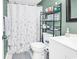 Bathroom with a white shower curtain, sleek fixtures, and decorative shelving at 1301 Pridgen Rd. # 903, Myrtle Beach, SC 29577