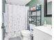 Bathroom with a white shower curtain, sleek fixtures, and decorative shelving at 1301 Pridgen Rd. # 903, Myrtle Beach, SC 29577