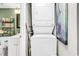 Modern laundry appliances adjacent to a bathroom with sleek fixtures, and decorative shelving at 1301 Pridgen Rd. # 903, Myrtle Beach, SC 29577