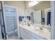 Full bathroom with tiled floors, white vanity, large mirror, and patterned shower curtain at 1427 Mcmaster Dr., Myrtle Beach, SC 29575