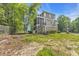View of a three-story home's backyard with a screened porch and wooded surroundings at 154 Harbor Oaks Dr., Myrtle Beach, SC 29588