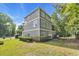 Rear exterior view of a three-story home with a grassy yard and patio area at 154 Harbor Oaks Dr., Myrtle Beach, SC 29588