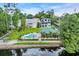 Waterfront view of a community pool and clubhouse amidst beautiful homes and trees at 154 Harbor Oaks Dr., Myrtle Beach, SC 29588