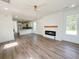 Open-concept living room with a fireplace, ceiling fan, wood-look floors, and lots of natural light at 189 Brown Pelican Loop, Pawleys Island, SC 29585