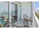 Inviting balcony with chairs and a table offers a view of the ocean and nearby buildings at 2000 N Ocean Blvd. # 1206, Myrtle Beach, SC 29577