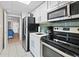 Compact kitchen featuring stainless steel appliances, white cabinets, and a stylish tiled backsplash at 2000 N Ocean Blvd. # 1206, Myrtle Beach, SC 29577