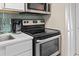 Close-up shot of kitchen with white cabinets, quartz countertop, stainless steel stove, and microwave at 2000 N Ocean Blvd. # 1206, Myrtle Beach, SC 29577