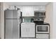 Compact kitchen featuring stainless steel appliances, white cabinets, and a stylish tiled backsplash at 2000 N Ocean Blvd. # 1206, Myrtle Beach, SC 29577