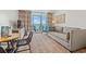Bright living room boasts balcony access with ocean views, a sofa, and colorful curtains at 2000 N Ocean Blvd. # 1206, Myrtle Beach, SC 29577