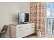 Living area includes a television, balcony access with ocean views, and colorful floral drapes at 2000 N Ocean Blvd. # 1206, Myrtle Beach, SC 29577