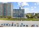 Aerial view of beachfront condos with blue umbrellas on a sunny beach at 2001 S Ocean Blvd. # 920, Myrtle Beach, SC 29577