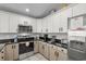 Bright kitchen featuring white cabinets, granite countertops, and stainless steel appliances at 221 N Waccamaw Dr., Murrells Inlet, SC 29576