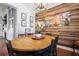 Dining room featuring a wooden table with black chairs, wood accent wall, and modern light fixture at 221 Rivers Edge Dr., Conway, SC 29526