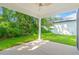 Covered patio with ceiling fan overlooking lush backyard greenery provides a relaxing outdoor space at 2241 Sand Dunes Dr., Myrtle Beach, SC 29577