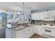 Bright kitchen with white cabinets, granite counters, and an open view of the living space and ocean at 300 N Ocean Blvd. # 128, North Myrtle Beach, SC 29582