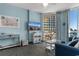 Comfortable living room with a balcony view, coastal decor, and convenient built-in storage at 300 N Ocean Blvd. # 128, North Myrtle Beach, SC 29582