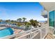 Scenic balcony view overlooking a pool area, beach, and palm trees, offering a relaxing beachfront experience at 300 N Ocean Blvd. # 128, North Myrtle Beach, SC 29582