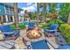 Outdoor oasis with a stone fire pit, Adirondack chairs, and a pool with palm trees in a fenced backyard at 315 14Th Ave. N, Surfside Beach, SC 29575