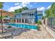 Inviting backyard featuring a sparkling pool, brick patio, lounge chairs, and a charming blue two-story home at 315 14Th Ave. N, Surfside Beach, SC 29575