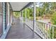 Inviting covered porch featuring classic white railings, dark wood flooring, and a tranquil view of the surrounding greenery at 315 14Th Ave. N, Surfside Beach, SC 29575