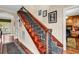 Elegant wooden staircase with decorative wrought iron railings and a patterned runner, creating a sophisticated entrance at 315 14Th Ave. N, Surfside Beach, SC 29575