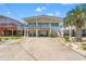 Coastal home with a large driveway, covered parking, and a white exterior with blue accents at 325 N 58Th Ave. N, North Myrtle Beach, SC 29582