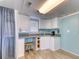 Small kitchenette features white cabinetry, wood look flooring, and a compact design, maximizing space and functionality at 325 N 58Th Ave. N, North Myrtle Beach, SC 29582