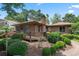 Charming home featuring a spacious deck, lush landscaping, and a brick chimney under a clear sky at 3533 Lighthouse Way, Myrtle Beach, SC 29577