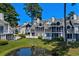 Exterior view of waterfront townhomes with screened porches and lush landscaping at 3835 Masters Ct. # 135, Myrtle Beach, SC 29577