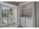 Bright laundry room with washer, dryer, window, and shelving for organized convenience at 3835 Masters Ct. # 135, Myrtle Beach, SC 29577