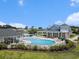 Stunning aerial view of a pool and lounge area surrounded by lush greenery under a clear blue sky at 4051 Mclamb Ave. # 4051, Little River, SC 29566