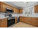 Updated kitchen featuring stainless steel appliances, wood cabinets, quartz countertops, and tile floors at 4539 Fringetree Dr., Murrells Inlet, SC 29576