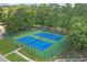 Aerial view of well-maintained blue tennis courts surrounded by lush green trees at 4539 Fringetree Dr., Murrells Inlet, SC 29576