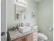 Bathroom with a modern sink, a decorative mirror, and light green walls at 528 George Washington Trail, Georgetown, SC 29440