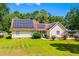 Inviting home exterior featuring solar panels, lush green lawn, and beautiful landscaping at 528 George Washington Trail, Georgetown, SC 29440