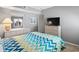 Inviting bedroom with calming decor, featuring a soft chevron bedspread and dresser with a mirror and TV at 609 Hillside Dr. S # D-17, North Myrtle Beach, SC 29582
