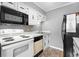 A well lit Kitchen has white cabinets, countertops, and modern black appliances at 609 Hillside Dr. S # D-17, North Myrtle Beach, SC 29582