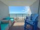 Relaxing balcony with blue Adirondack chairs and cushioned seating overlooking the ocean at 7200 N Ocean Blvd. # 1160, Myrtle Beach, SC 29572